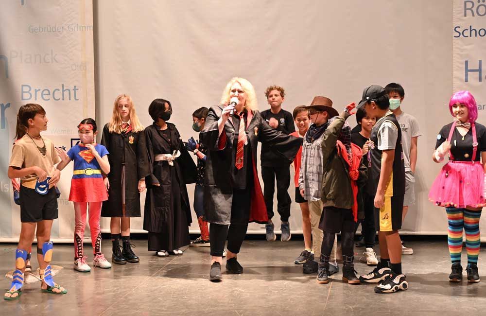 A group of children dressed in costumes are standing on a stage.