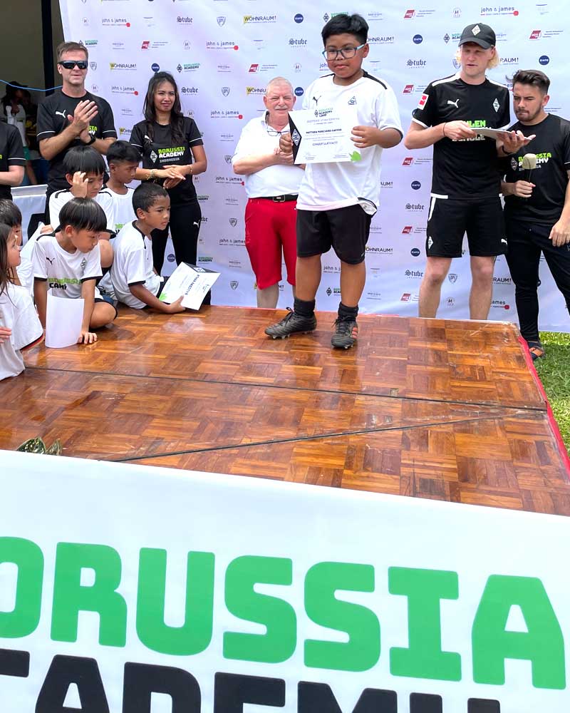 A group of people standing on a stage in front of a sign that says russia academy