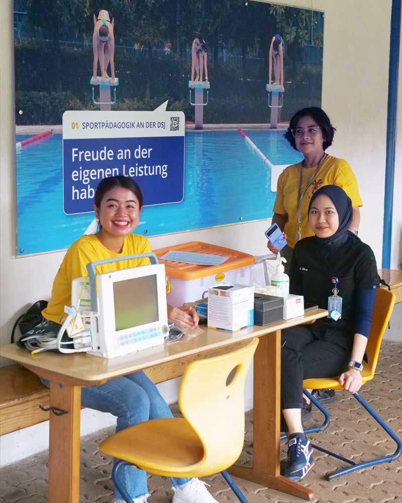 Three women are sitting at a table in front of a sign that says freude an der eigenen leistung hab