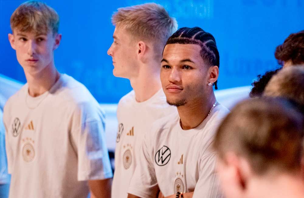 A group of young men are standing next to each other wearing white shirts.