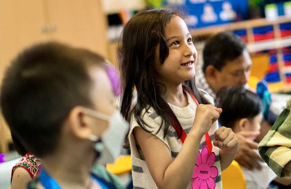 A group of children are sitting in a classroom.