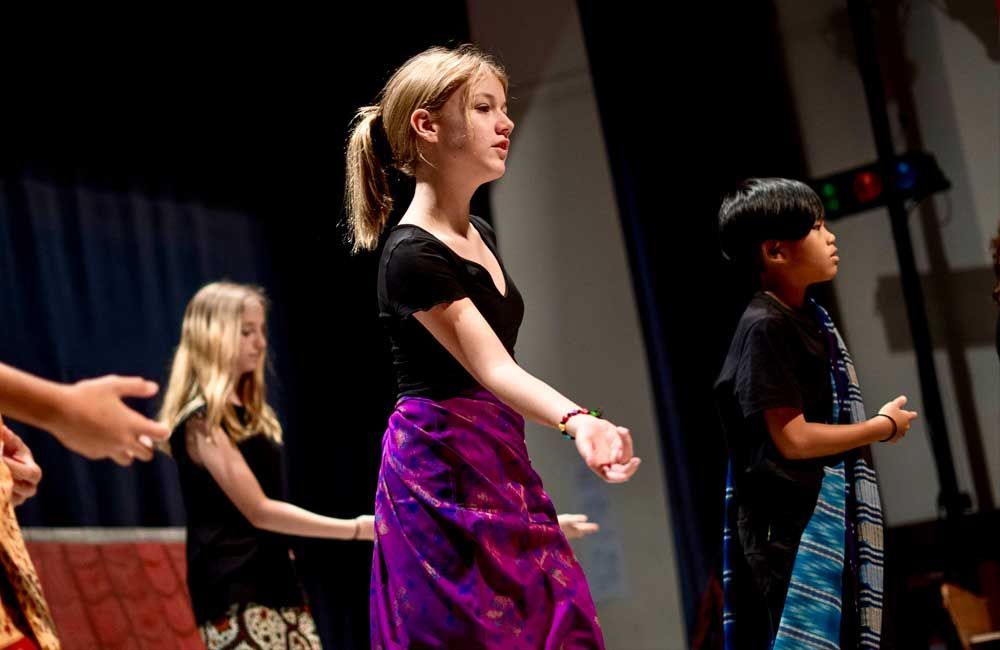A group of children are dancing on a stage.