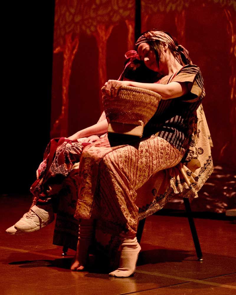 A woman is sitting on a chair holding a basket