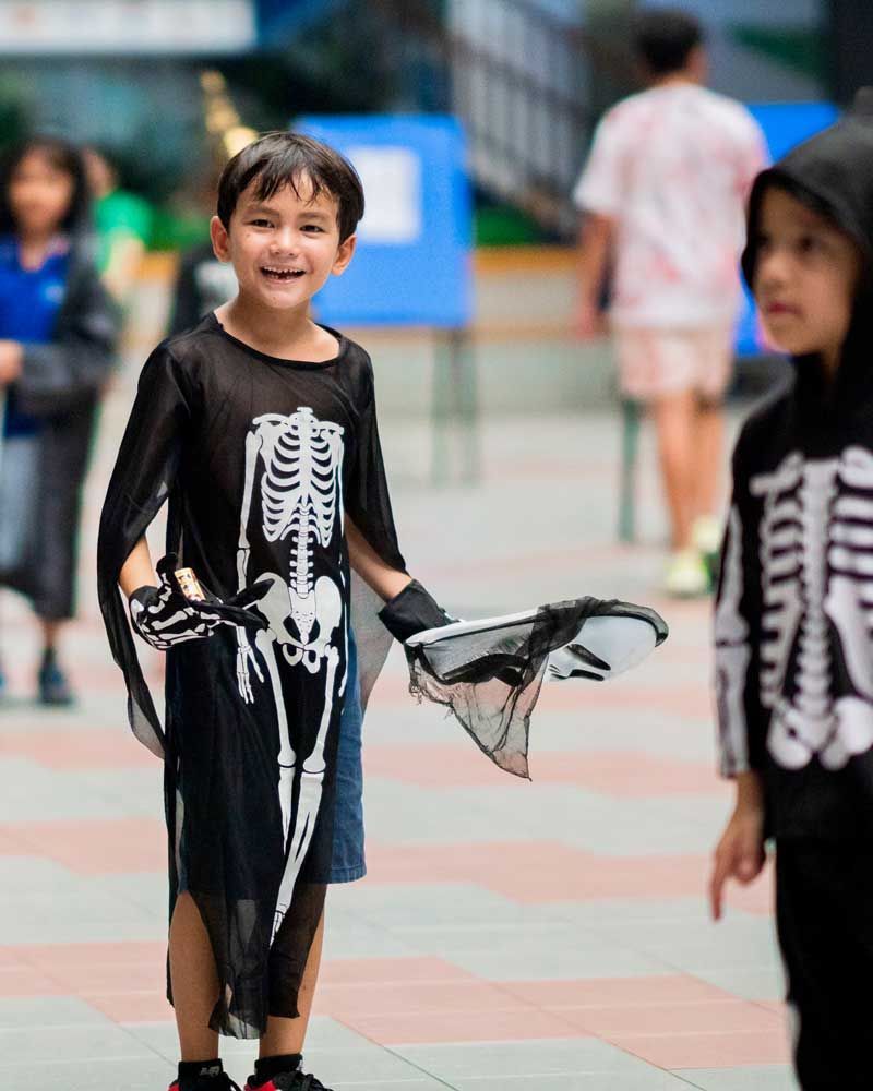 A boy in a skeleton costume is standing next to a girl in a skeleton costume.