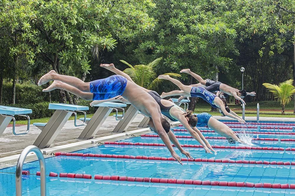 Students jump into the swimming pool at the German School Jakarta