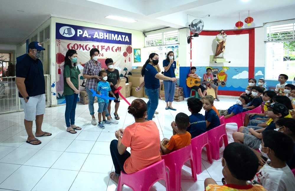 A group of people are sitting in pink chairs in a room.