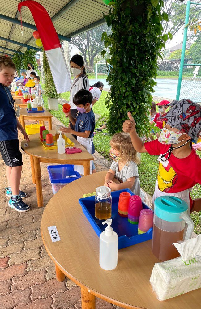 A group of children are playing with water at a table.