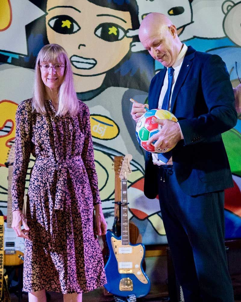 A man and a woman standing next to each other in front of a mural