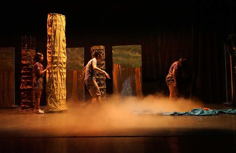 A group of people are standing on a stage with smoke coming out of it.