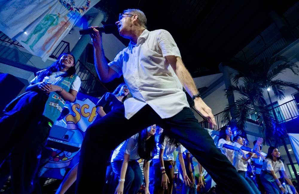 A man singing into a microphone in front of a crowd