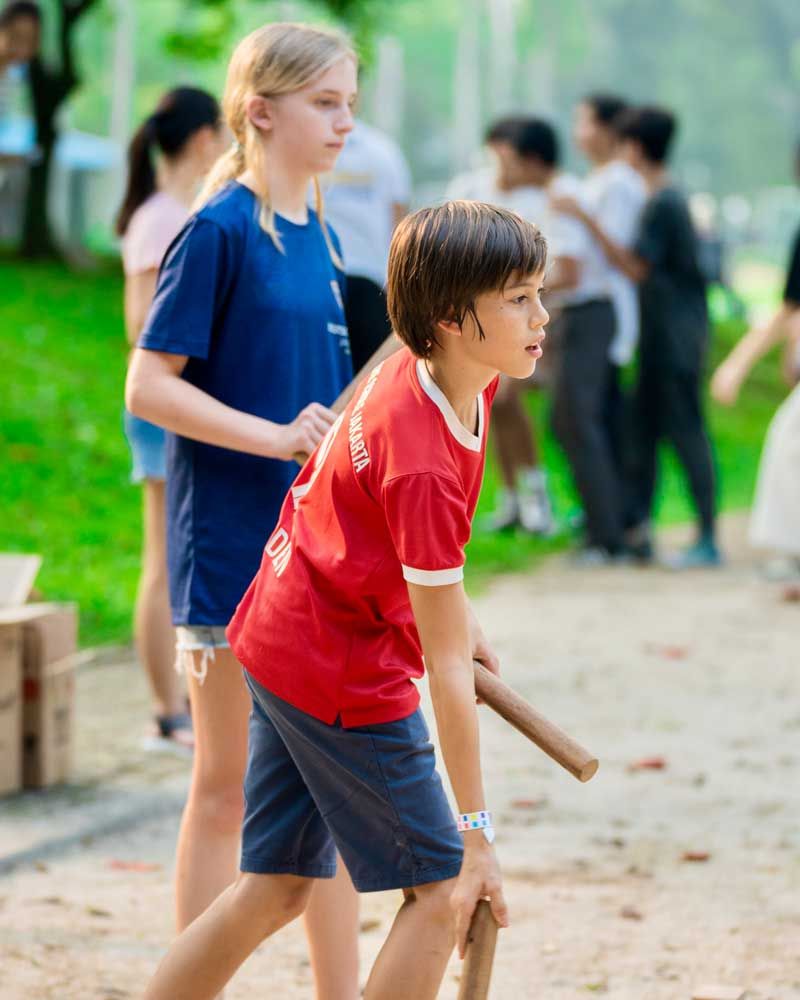 A boy in a red shirt is walking next to a girl in a blue shirt.