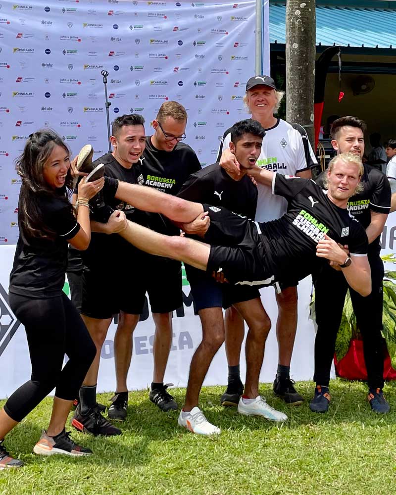 A group of people are holding a man up in the air.