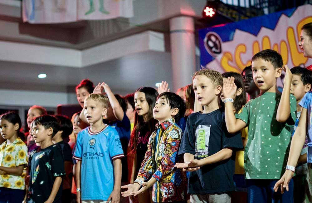 A group of children are singing together in a room.