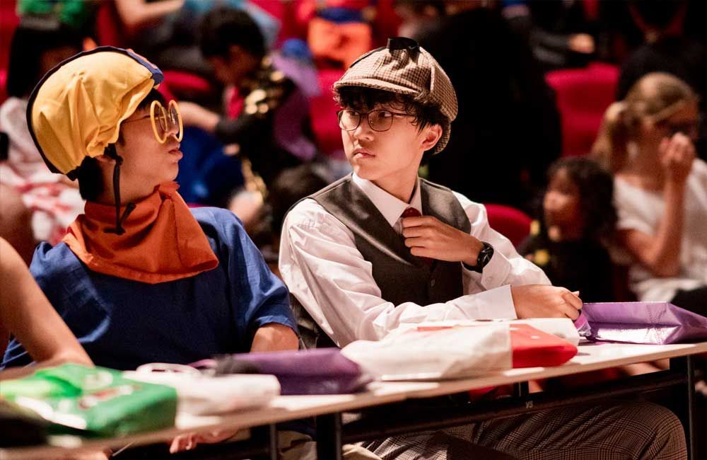 A group of children are sitting at a table in a classroom.