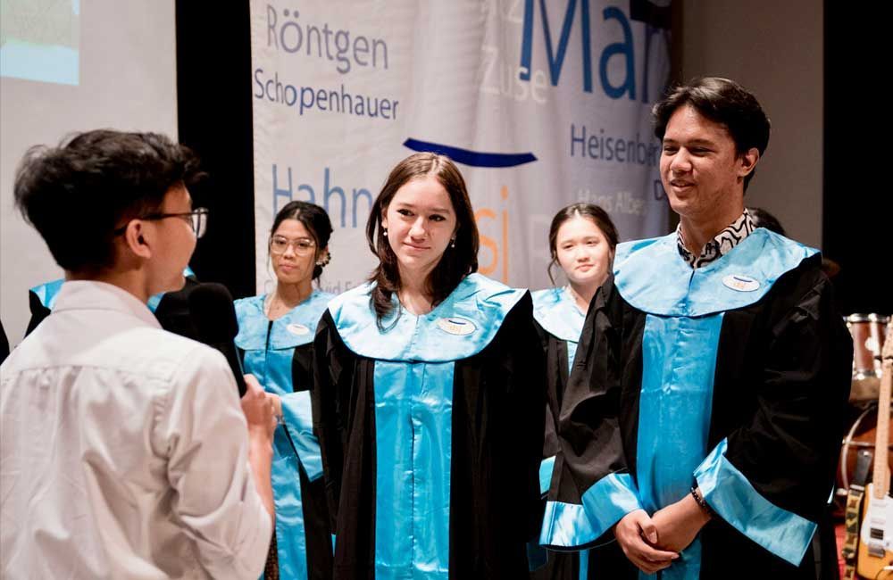 A group of people in graduation gowns are standing next to each other.