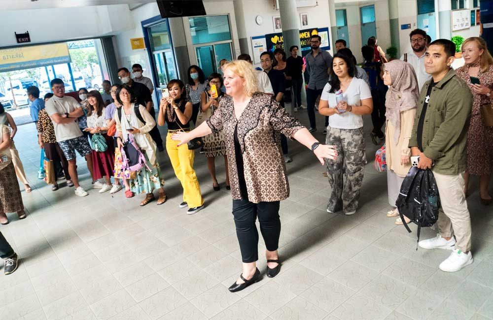 A woman is standing in front of a crowd of people.