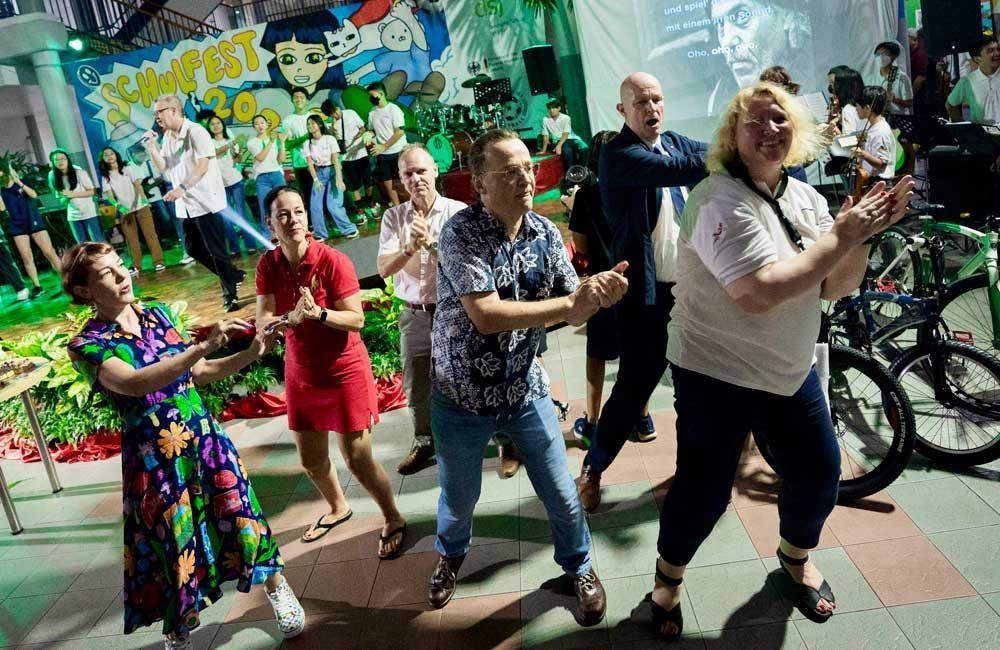 A group of people are dancing together in a room.