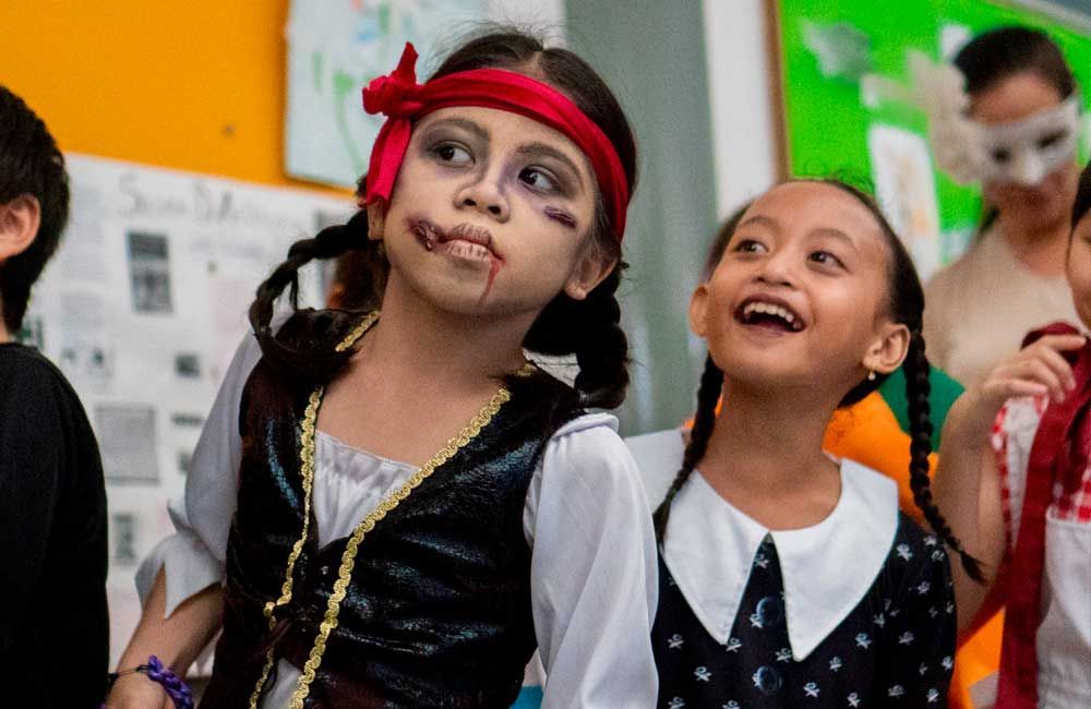 A group of children are dressed up in costumes for halloween.
