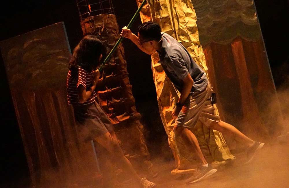 A man and a woman are standing next to each other on a stage.