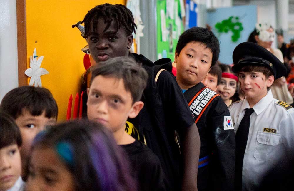 A group of children dressed in costumes are standing in a line.