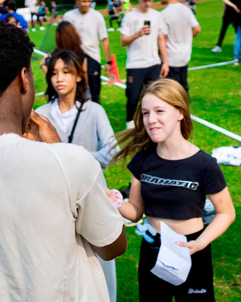 A girl wearing a black shirt that says ' warner ' on it