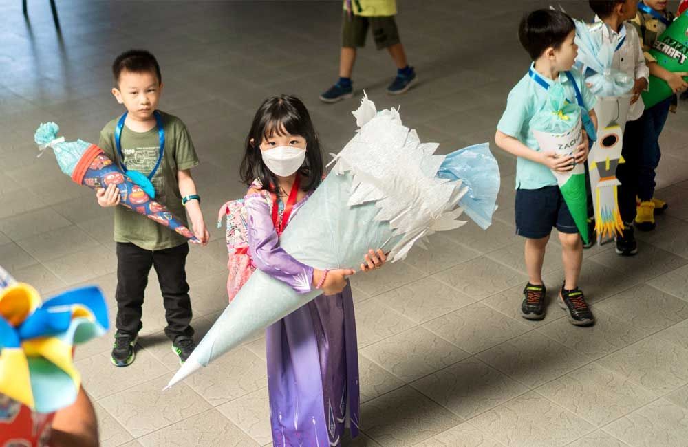 A girl wearing a mask is holding a large cone.