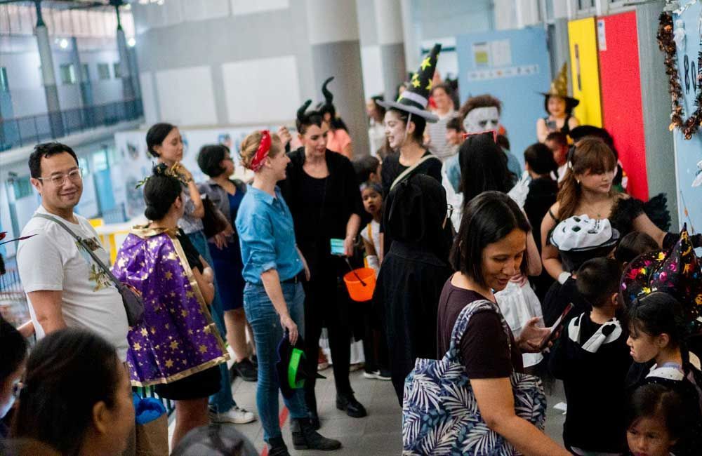 A group of people dressed in halloween costumes are standing in a room.