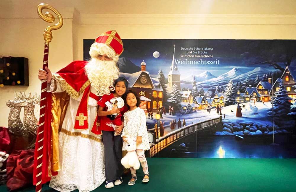 A man dressed as santa claus is posing for a picture with two children.