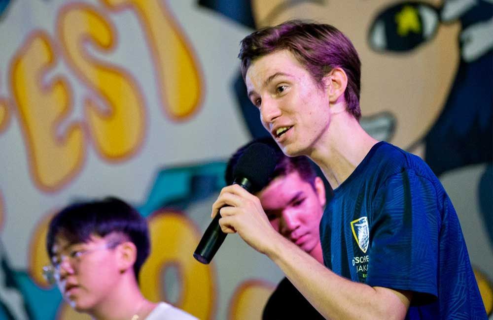 A man is holding a microphone in front of a group of people.