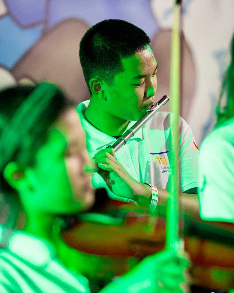 A man in a white shirt is playing a flute