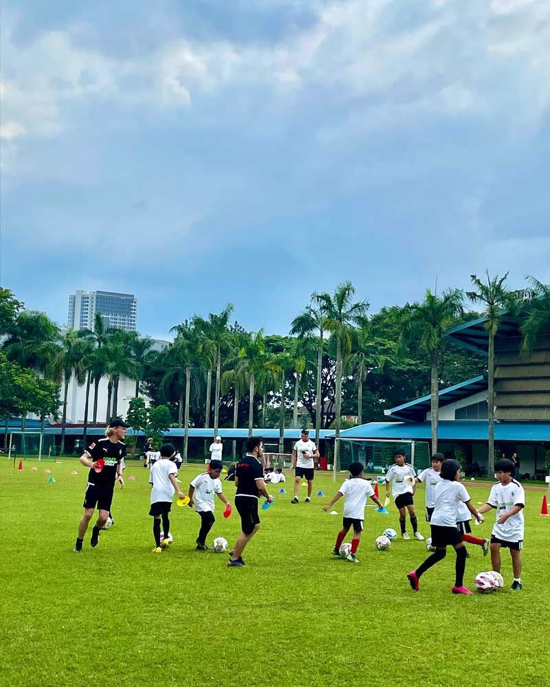 A group of children are playing soccer on a field.