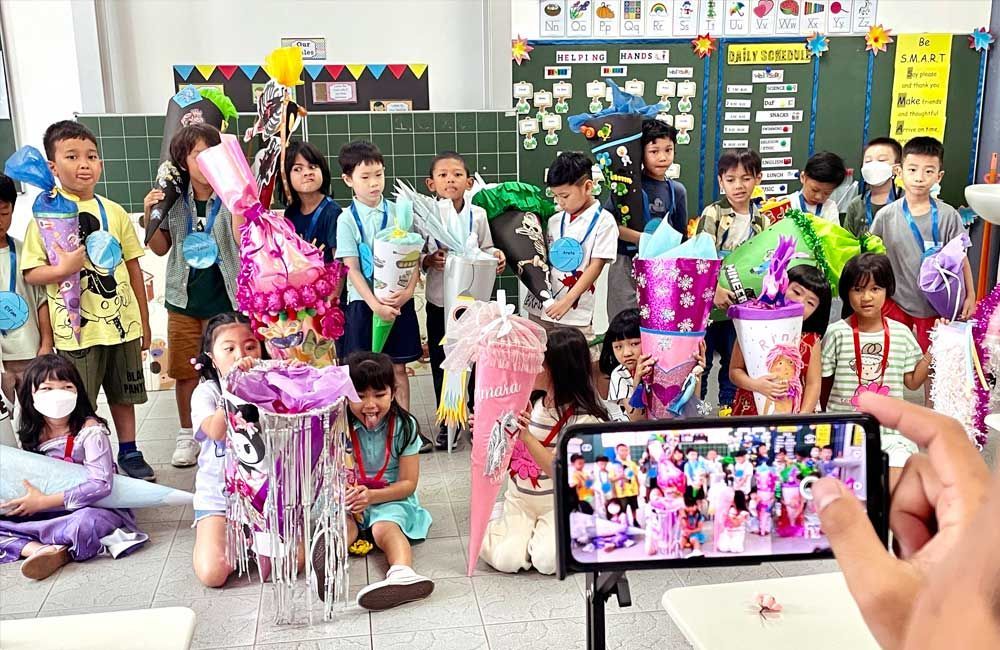 A person is taking a picture of a group of children in a classroom.