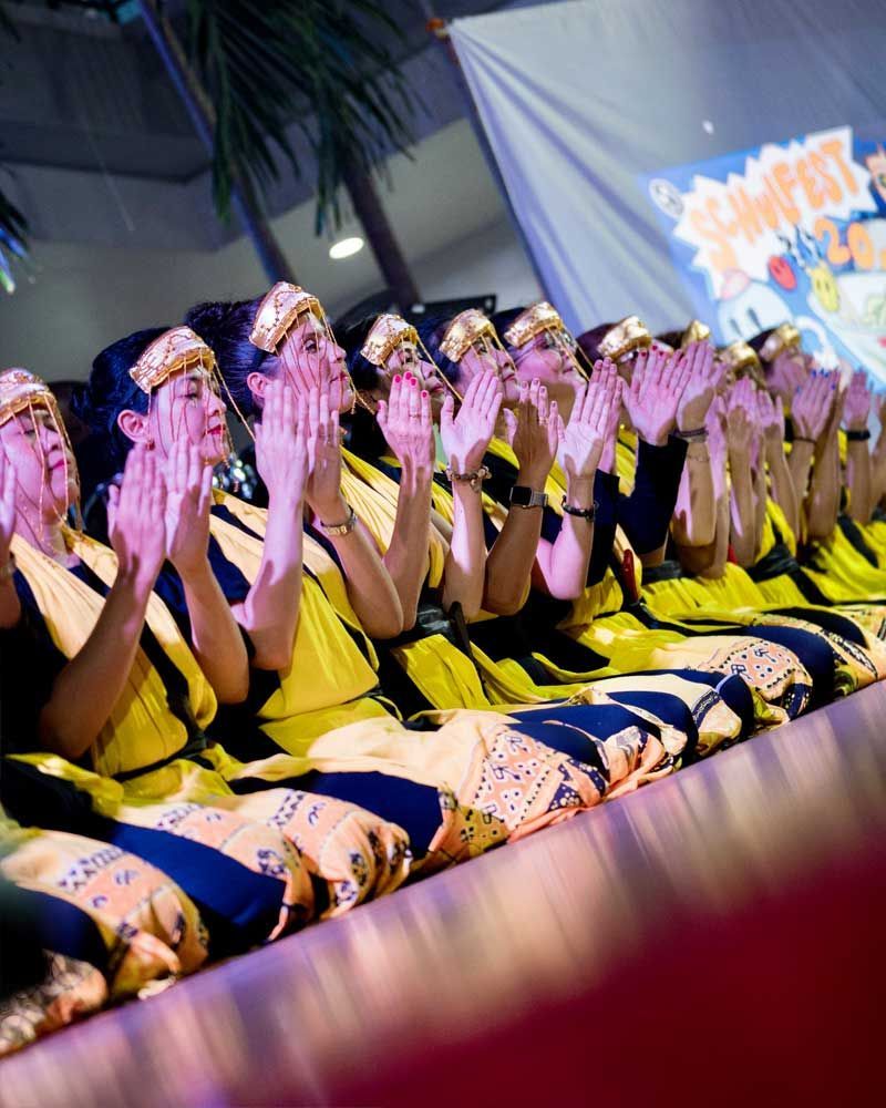 A group of people sitting on a stage clapping their hands