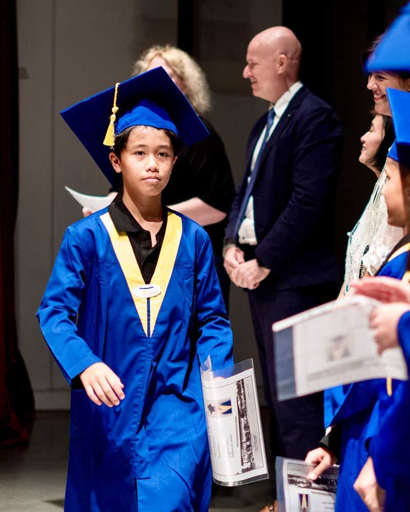 A young boy in a blue graduation cap and gown