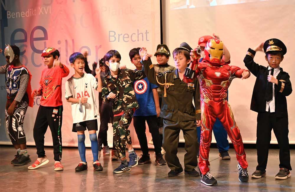A group of children dressed in costumes are standing on a stage.