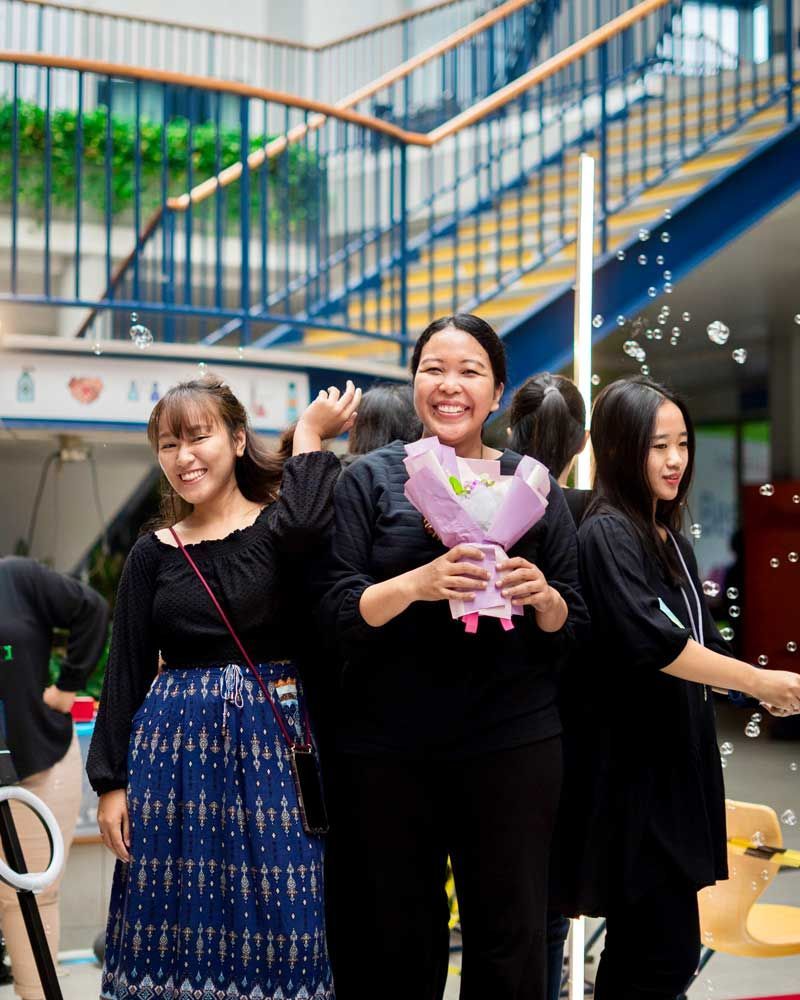 A group of young women are posing for a picture in front of a staircase.