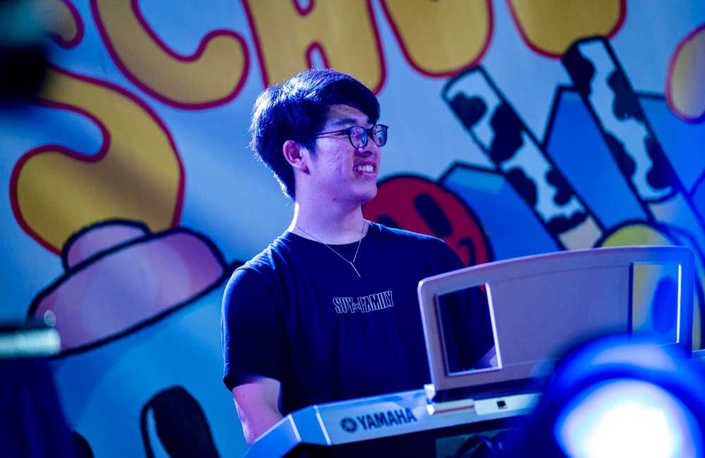 A young man is playing a yamaha keyboard on stage.