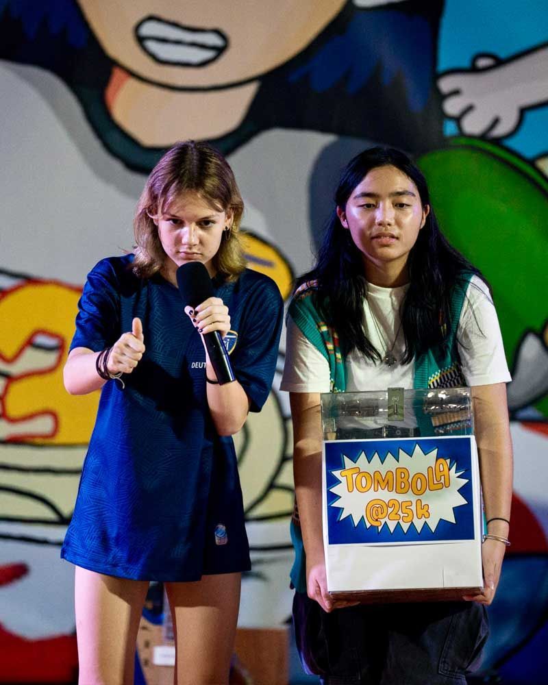 Two girls are standing next to each other holding a box that says ' tomboy dash ' on it