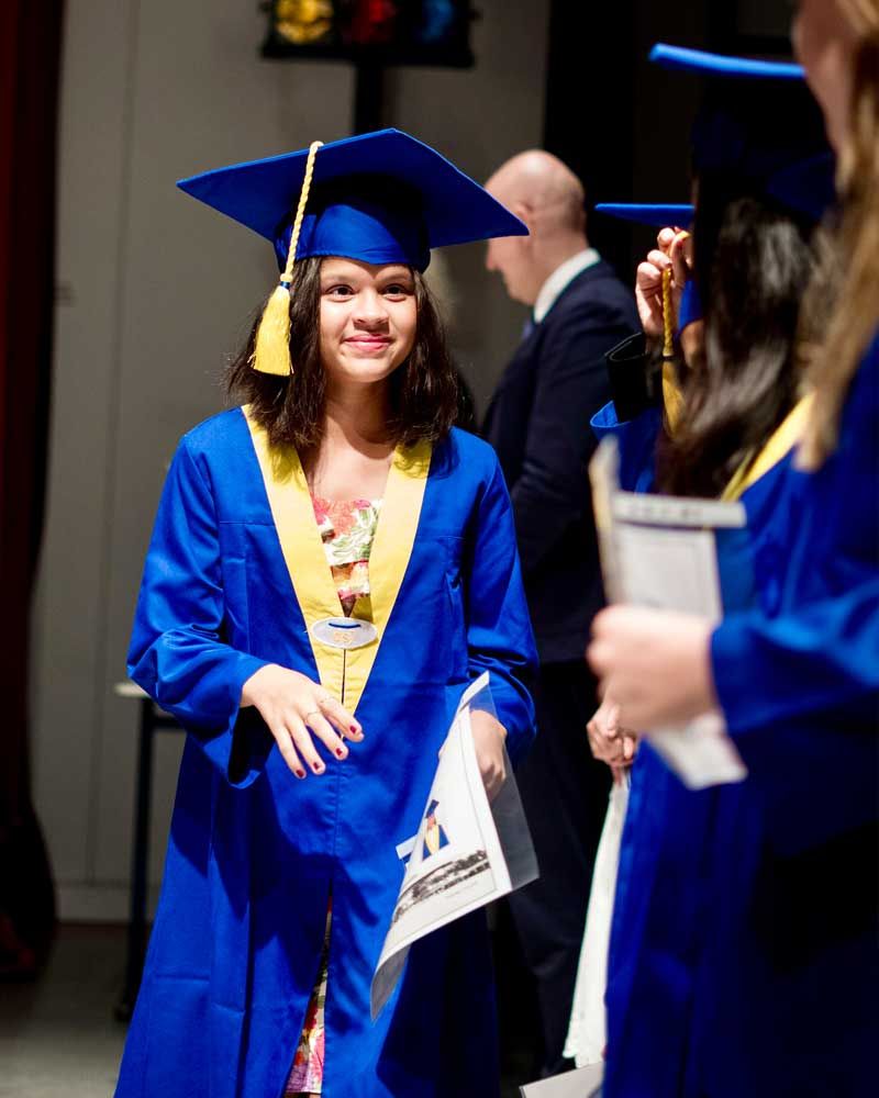 A girl in a blue graduation cap and gown