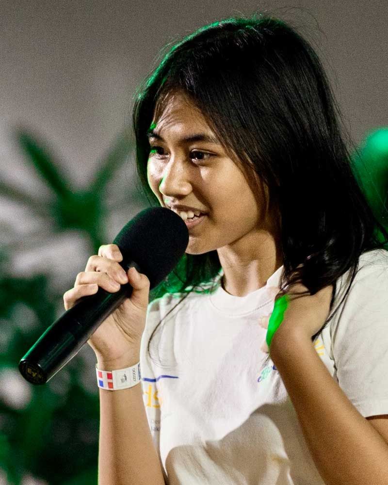 A young woman is singing into a microphone.