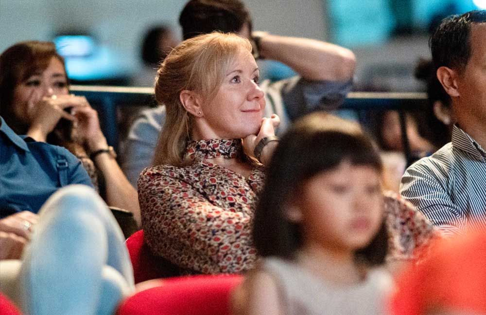 A group of people are sitting in a theater watching a movie.