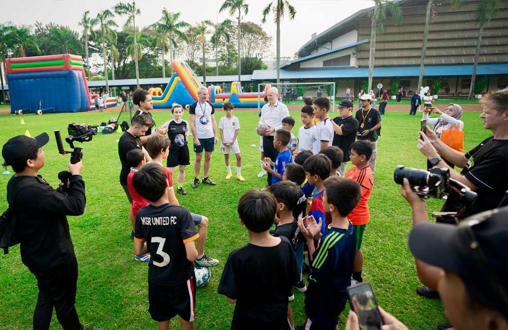 A group of children are standing in a circle on a soccer field.