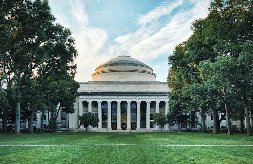 A large building with a dome in the middle of a park surrounded by trees.