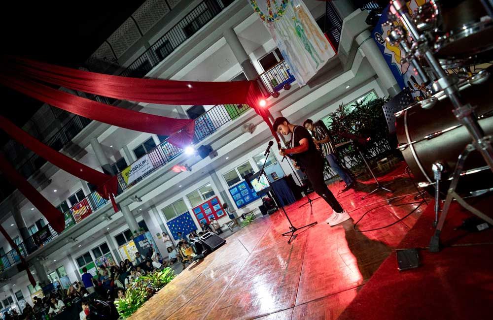 A man is playing a guitar on a stage in front of a crowd.