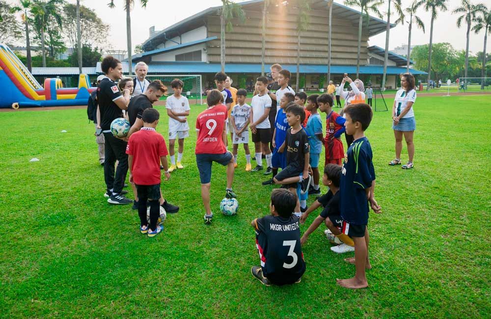 A group of children are playing soccer on a field.