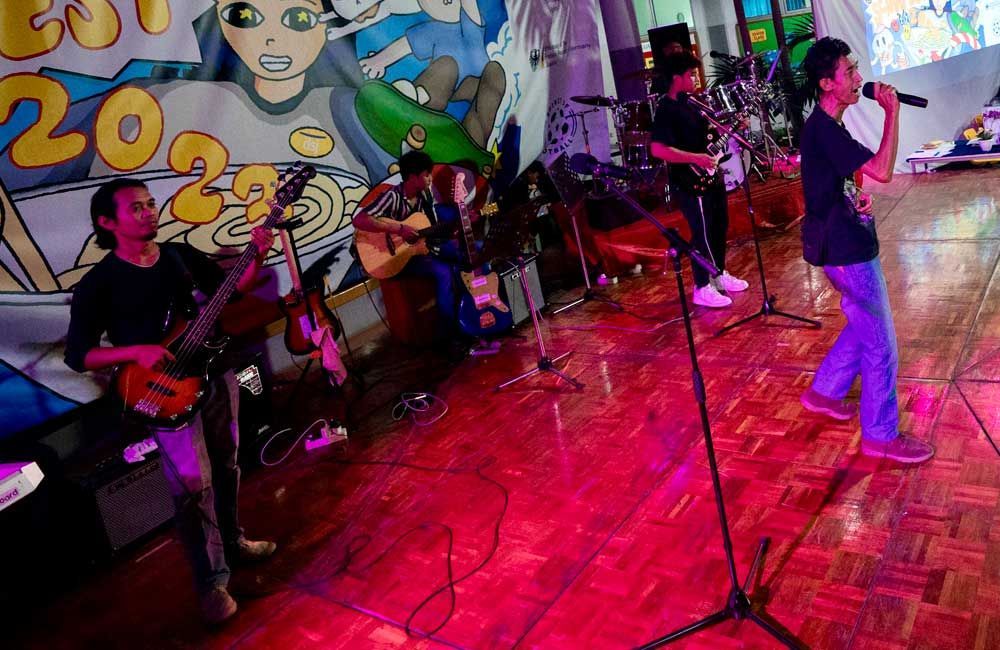 A group of people are playing instruments and singing on a stage.