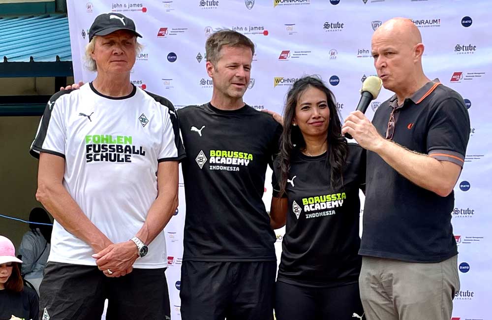 A group of people standing next to each other with a man holding a microphone.