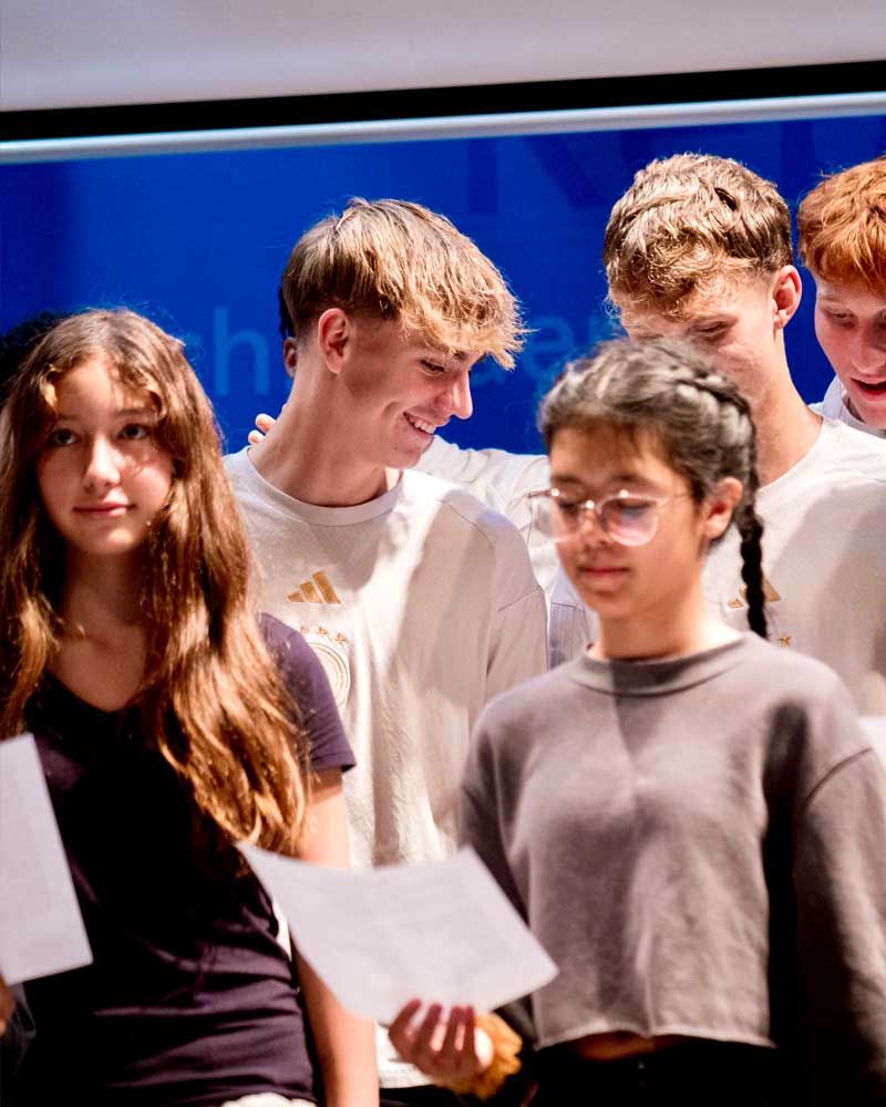 A group of young people standing in front of a blue screen