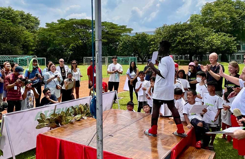 A man is standing on a stage in front of a crowd of people.