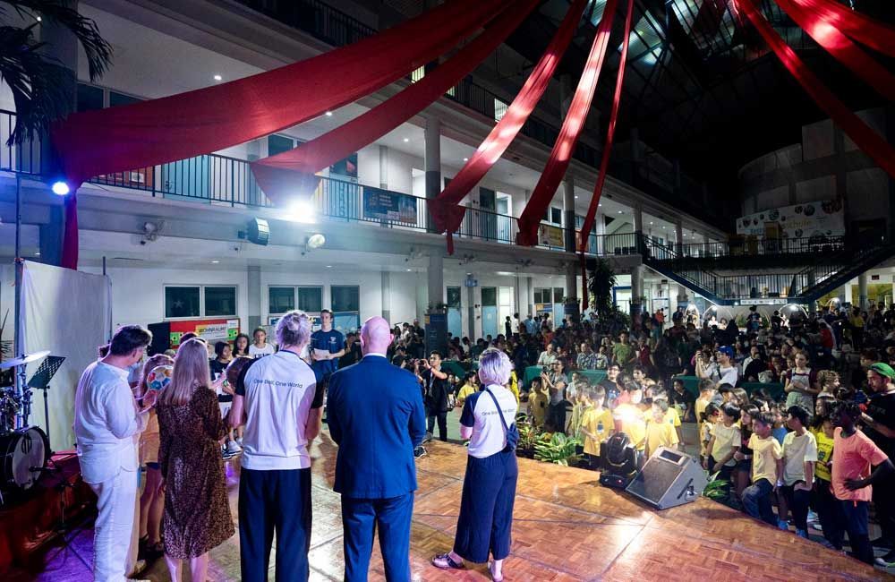A group of people are standing on a stage in front of a large crowd.